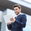 cheerful-business-manager-tablet-computer-checking-documents-online-centre-city-panorama-188586355